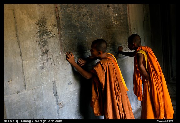 Two buddhist monks examine  bas-reliefs in Angkor Wat. Angkor, Cambodia (color)