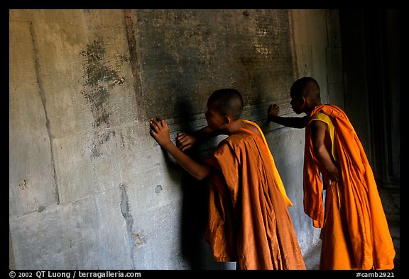 Two buddhist monks examine  bas-reliefs in Angkor Wat. Angkor, Cambodia