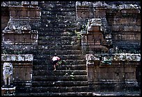 Boy climbs near-vertical staircase, Angkor Thom complex. Angkor, Cambodia (color)