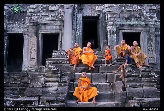 Buddhist monks sitting on steps, Angkor Wat. Angkor, Cambodia