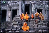 Buddhist monks sitting on steps, Angkor Wat. Angkor, Cambodia