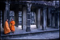 Two Buddhist monks in dark temple, Angkor Wat. Angkor, Cambodia