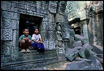 Boy and girl sit at window in Ta Prom. Angkor, Cambodia