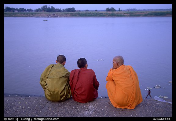 Buddhist monks sit on  banks of Tongle Sap river at dusk,  Phnom Phen. Cambodia (color)