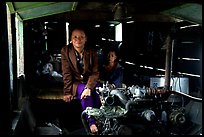 Engine and pilot at the rear of a slow passenger boat. Mekong river, Laos (color)