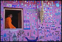 Buddhist novice monk sits at window of shrine, Wat Xieng Thong. Luang Prabang, Laos ( color)