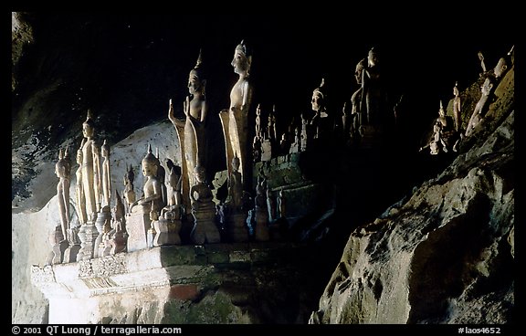 Hundreds of wooden Buddhist figures on wall shelves, Pak Ou caves. Laos (color)