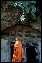 Novice Buddhist monk at entrance of lower Pak Ou cave. Laos (color)