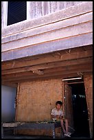 Boy at the entrance of traditional hut, Ban Xang Hai. Laos (color)