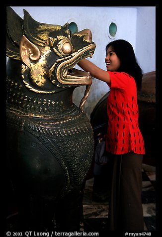 Rubbing an Angkor bronze statue at Mahamuni Paya. Mandalay, Myanmar
