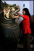 Rubbing an Angkor bronze statue at Mahamuni Paya. Mandalay, Myanmar (color)