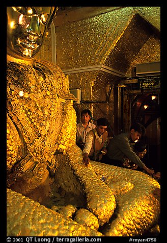 Adding golden leaves to the venerated Mahamuni image. Mandalay, Myanmar (color)