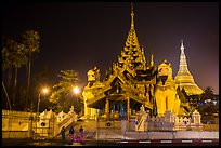 Southern gate guarded by two leogryphs and Main Stupa at night, Shwedagon Pagoda. Yangon, Myanmar