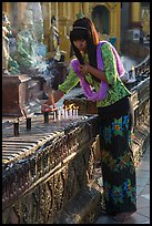 Woman lighting candles, Shwedagon Pagoda. Yangon, Myanmar