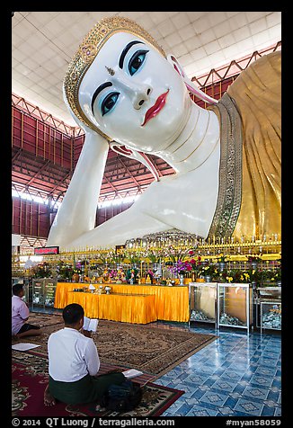 Men praying in front of reclining Buddha statue, Kyauk Htat Gyi Pagoda. Yangon, Myanmar (color)