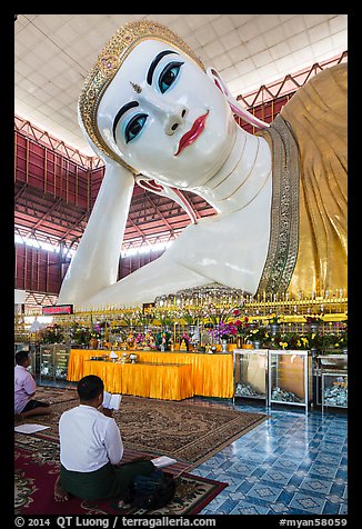 Men praying in front of reclining Buddha statue, Kyauk Htat Gyi Pagoda. Yangon, Myanmar (color)