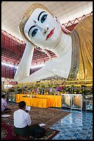 Men praying in front of reclining Buddha statue, Kyauk Htat Gyi Pagoda. Yangon, Myanmar ( color)