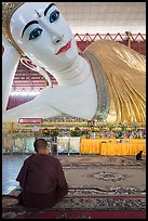 Monk praying in front of reclining Buddha statue, Kyaukhtatgyi Pagoda. Yangon, Myanmar ( color)