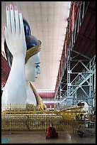 Monk and reclining Buddha statue housed in large metal shed, Kyauk Htat Gyi Pagoda. Yangon, Myanmar ( color)