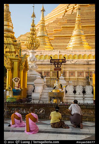 Nuns and couple worshipping at planetary station, Shwedagon Pagoda. Yangon, Myanmar (color)