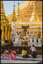 Nuns and couple worshipping at planetary station, Shwedagon Pagoda. Yangon, Myanmar ( color)