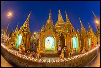 Oil lamps and stupas at dusk, Shwedagon Pagoda. Yangon, Myanmar