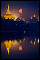 Full Moon setting over Shwedagon Pagoda and Kandawgyi Lake. Yangon, Myanmar