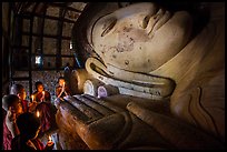 Young monks with candles worship Shin Bin Thal Yaung reclining Budddha. Bagan, Myanmar ( color)