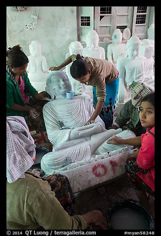 Women polishing buddha statue. Mandalay, Myanmar (color)