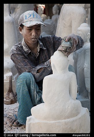 Sculptor carving buddha statue out of a block of white marble. Mandalay, Myanmar