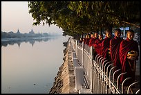 Monks walking in line in alm bowls near Mandalay Fort moat. Mandalay, Myanmar ( color)