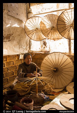 Woman assembling the paper umbrellas carried by the monks. Pindaya, Myanmar (color)