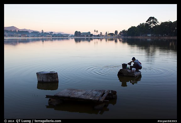 Woman washing laundry in Pone Tanoke Lake at dawn. Pindaya, Myanmar (color)