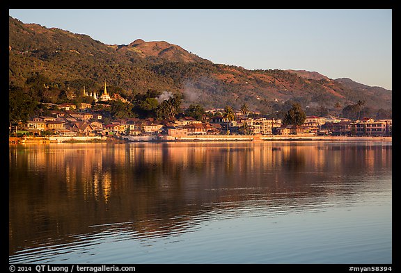 Hill and town reflected in Pone Tanoke Lake at sunrise. Pindaya, Myanmar (color)