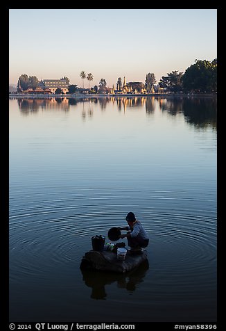 Woman washing laundry in Pone Tanoke Lake at sunrise. Pindaya, Myanmar (color)