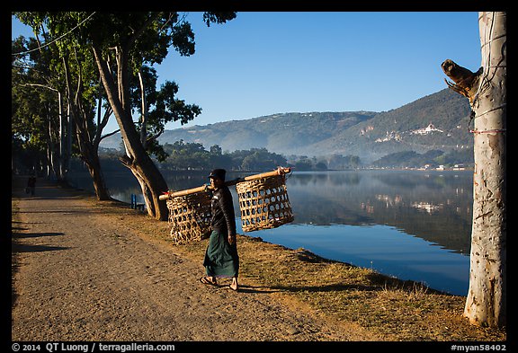Man carrying baskets on road near Pone Tanoke Lake. Pindaya, Myanmar (color)