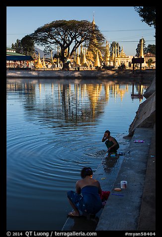 Women washing and doing laundry in lake with pagoda in background. Pindaya, Myanmar (color)