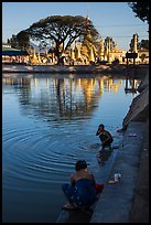 Women washing and doing laundry in lake with pagoda in background. Pindaya, Myanmar ( color)