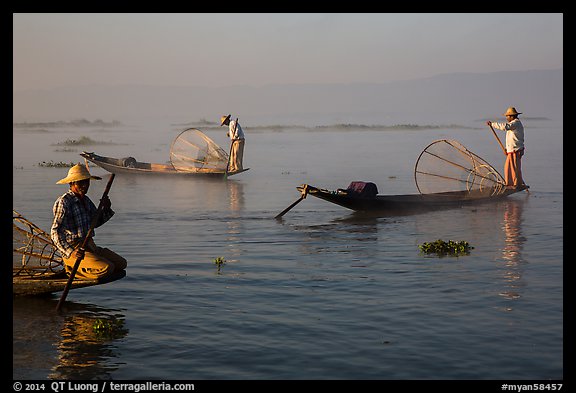 Intha fishermen rowing boats in early morning mist. Inle Lake, Myanmar (color)