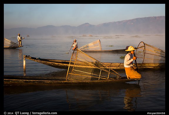 Intha fishermen with conical baskets in morning mist. Inle Lake, Myanmar (color)