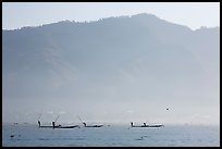 Intha fishermen in the distance using spears to stir fish, below tall hills. Inle Lake, Myanmar ( color)