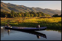 Woman riding with child in front of boat in Maing Thauk Village. Inle Lake, Myanmar ( color)