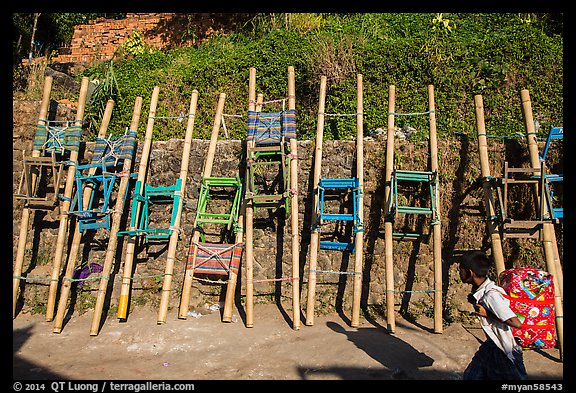 Child walking past sedan chairs. Kyaiktiyo, Myanmar (color)
