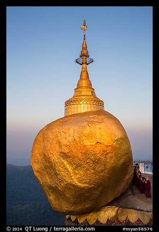 Monks standing in prayer near the Golden rock at sunrise. Kyaiktiyo, Myanmar (color)