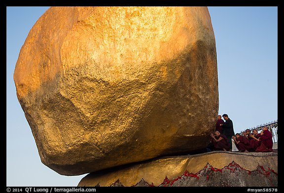 Monks kneeling in prayer at the Golden Rock. Kyaiktiyo, Myanmar (color)