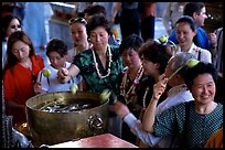 Worshippers dip lotus flowers and bring them to their heads. Bangkok, Thailand ( color)