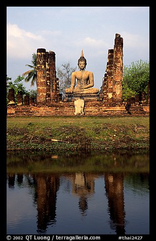 Buddha image reflected in moat, morning, Wat Mahathat. Sukothai, Thailand