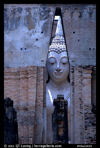 Monumental Buddha image seen between walls,  Wat Si Chum. Sukothai, Thailand