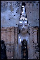 Monumental Buddha image seen between walls,  Wat Si Chum. Sukothai, Thailand (color)