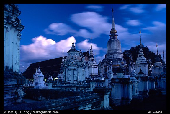 Chedis in blue light with bright clouds, Wat Suan Dok, dusk. Chiang Mai, Thailand (color)